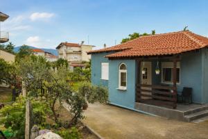 a blue house with a red roof at Goldtown House in Chrysoupolis