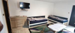 a room with two bunk beds and a flat screen tv at Apartament Przylesie 2 in Stężyca