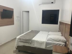 a bedroom with a bed and a flat screen tv at Hotel Real Centro in São Paulo