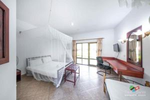 a bedroom with a white bed and a desk at Tan-Swiss Lodge in Mikumi