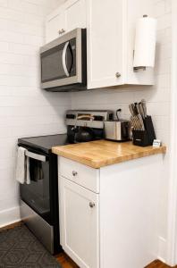 a kitchen with a stove and a microwave at Modern Main Street Charm in Georgetown