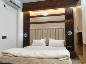 a bedroom with a large bed with white sheets at Orange Elite Stays Whitefield in Bangalore +7 photos