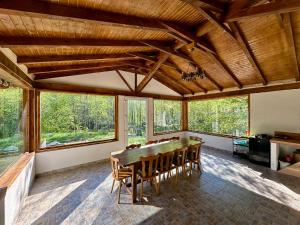 a dining room with a wooden table and chairs at La Izvoare in Clopotiva
