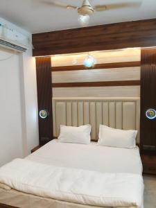 a white bed with two pillows in a room at Orange Elite Stays Whitefield in Bangalore