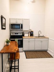 a kitchen with white cabinets and a wooden table at Main Street Stay in Georgetown +6 photos