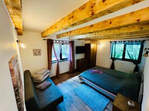 a bedroom with a green bed and two windows at La Izvoare in Clopotiva
