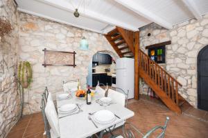 a dining room with a table and a stone wall at Villa Demetra in Áyios Dhimítrios