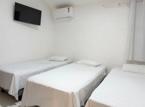 a room with two beds and a tv on the wall at Studios Congresso suites e Lofts Duplex in Brasília