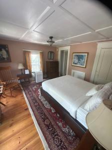 a bedroom with a large bed and a living room at The old parsonage bed and breakfast in Kennebunkport