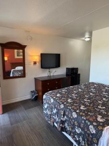 a hotel room with a bed and a flat screen tv at Travel Inn in Greensboro +11 photos