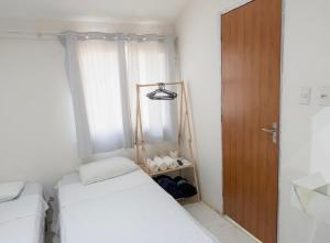 a small room with two beds and a wooden door at Studios Congresso suites e Lofts Duplex in Brasília