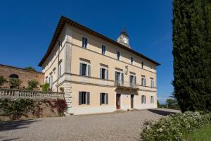 a large white building with a clock tower on top at Borgo Villa Certano - Case Vacanza in Toscana in Siena