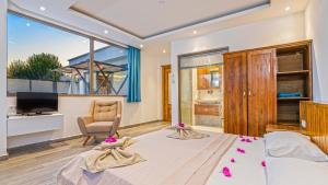 a bedroom with a bed and a desk and a television at Secluded Sea-View Family Escape-Villa Bella2 Sardunya in Üzümlü