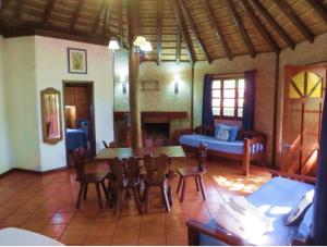 a living room with a couch and a table and chairs at Casa de Piedra in Termas del Daymán