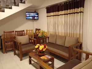 a living room with a couch and chairs at Sobasee Holiday Bungalow in Kandy