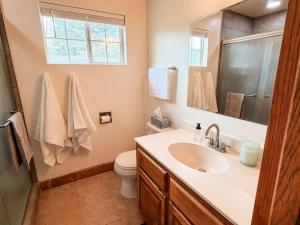 a bathroom with a sink and a toilet and a mirror at Lake and Mountains, 3BR 2BA in Show Low +19 photos
