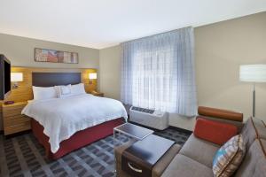 a hotel room with a bed and a couch at TownePlace Suites by Marriott Brookfield in Brookfield +44 photos