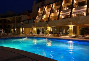a swimming pool in front of a building at night at chalet in Saint remon in Al ‘Ayn