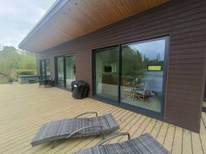 a deck with two chairs and a table on it at Egret Woody Park in Willand