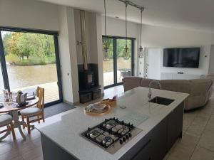 a kitchen and living room with a stove top oven at Egret Woody Park in Willand