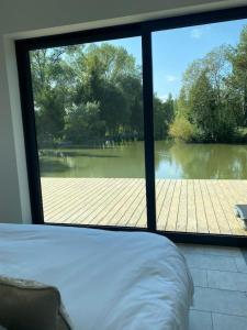 a bedroom with a view of a river from a window at Egret Woody Park in Willand