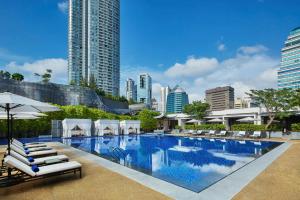 a large swimming pool with lounge chairs and buildings at Singapore Marriott Tang Plaza Hotel in Singapore