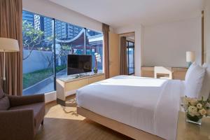 a bedroom with a large white bed and a television at Singapore Marriott Tang Plaza Hotel in Singapore
