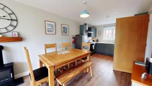 a kitchen and dining room with a wooden table at Ocean Cove - Part of the The Bay Filey Holiday Village with pool, gym and direct beach access, pub, restaurant, tennis and meadows walks in Reighton