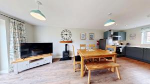 a living room with a dining table and a television at Ocean Cove - Part of the The Bay Filey Holiday Village with pool, gym and direct beach access, pub, restaurant, tennis and meadows walks in Reighton