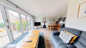 a living room with a couch and a table at Ocean Cove - Part of the The Bay Filey Holiday Village with pool, gym and direct beach access, pub, restaurant, tennis and meadows walks in Reighton