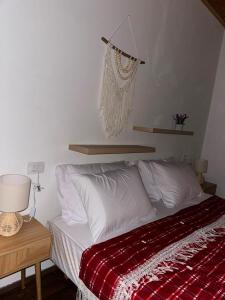 a bedroom with a bed with a red and white blanket at Guest House Keli in Nënshat