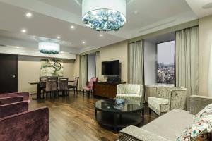 ein Wohnzimmer mit Sofa, Sesseln und Fernseher in der Unterkunft Sheraton Bucharest Hotel in Bukarest + 64 Fotos