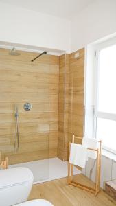 a bathroom with a shower with a toilet and a chair at Aura Apartments in Pompei
