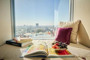 Ein Buch und eine Obstschale neben einem Fenster in der Unterkunft Sheraton Bucharest Hotel in Bukarest