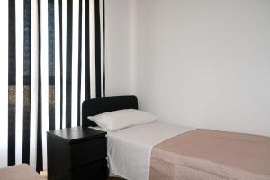 a bedroom with a bed and a chair next to a window at Aura Apartments in Pompei +9 photos