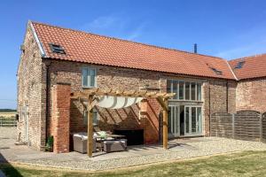 a brick building with an outdoor patio with an umbrella at 4 Bed in Brough oc-93496 in Brough