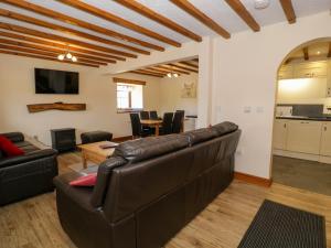 a living room with a leather couch and a table at Cornel Clyd in Llanddulas