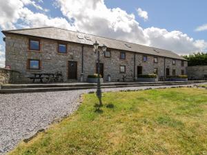 a large stone building with a bench in front of it at Cornel Clyd in Llanddulas