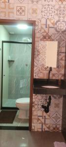 a bathroom with a toilet and a glass shower at Quarto Privativo in Caparaó Velho +12 photos