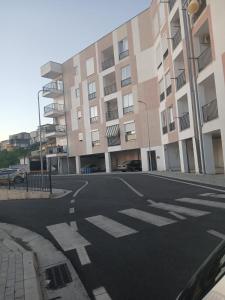 an empty street in front of a large building at Enes apartament in Krujë