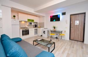 a living room with a blue couch and a table at Harmony Suites in Bucharest