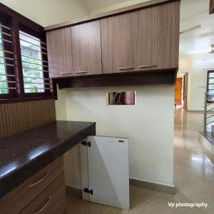 a kitchen with wooden cabinets and a counter top at Trinity Mansion in Mangalore +7 photos