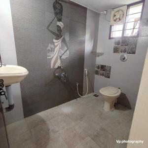 a bathroom with a shower and a toilet and a sink at Trinity Mansion in Mangalore