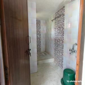 a bathroom with a shower with a glass door at Trinity Mansion in Mangalore