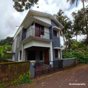 a blue and white house with a balcony at Trinity Mansion in Mangalore