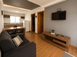 a living room with a couch and a table at Flat com Jacuzzi - Cantinho do Lago 2 in Capitólio