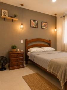 a bedroom with a bed and a wooden headboard and a table at Flat com Jacuzzi - Cantinho do Lago 2 in Capitólio +10 photos