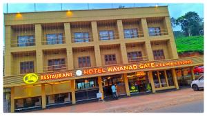 a building with a man standing in front of it at Hotel Wayanad Gate in Wayanad