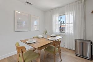 a dining room with a table and chairs and a television at LA Gramercy in Los Angeles