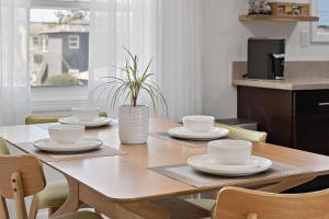 a dining room table with white dishes and a plant at LA Gramercy in Los Angeles